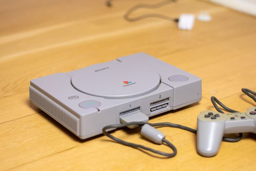 An Original Playstation 1, by Sony, on a wooden floor.