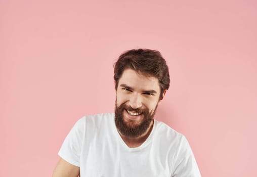 Portrait of a man in a white T-shirt on a pink background close-up model. High quality photo