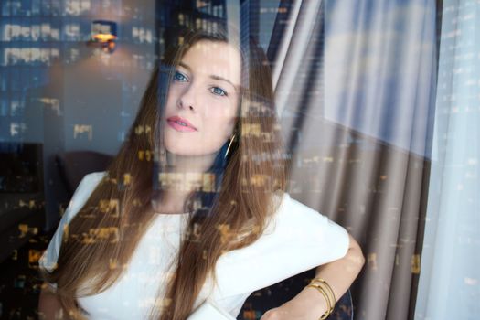 Chic business woman looking out the office window in downtown, work and career concept