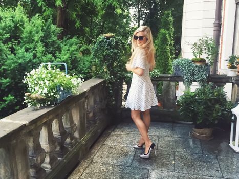 Beautiful model woman wearing polka dots dress in spring garden, luxury fashion and beauty brands