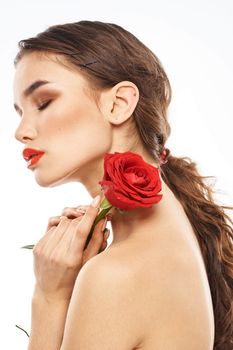 Beautiful woman with red rose near face makeup naked shoulders portrait. High quality photo