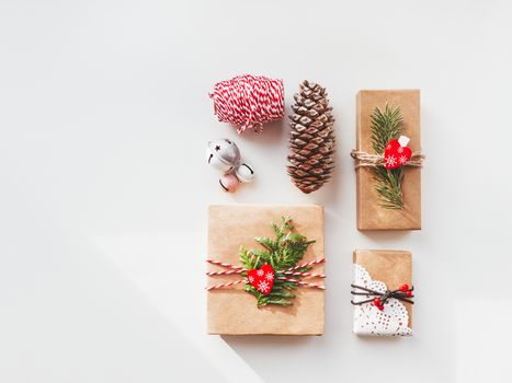 Christmas DIY presents wrapped in craft paper with fir tree twigs and red hearts. Top view on decorations on New Year gifts. Festive background. Winter holiday spirit. Banner with copy space.