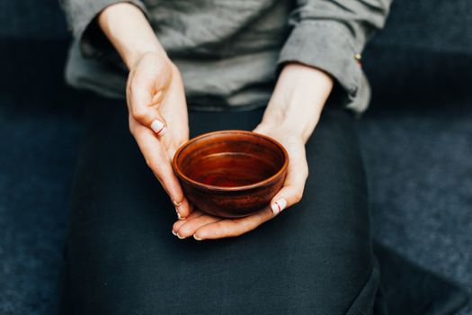 Woman offers hot tea in a vintage ceramic cup. Traditional tea ceremony