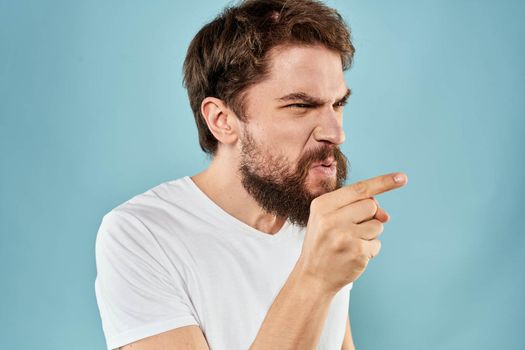 Man with disgruntled facial expression gesturing with hands studio lifestyle blue background. High quality photo