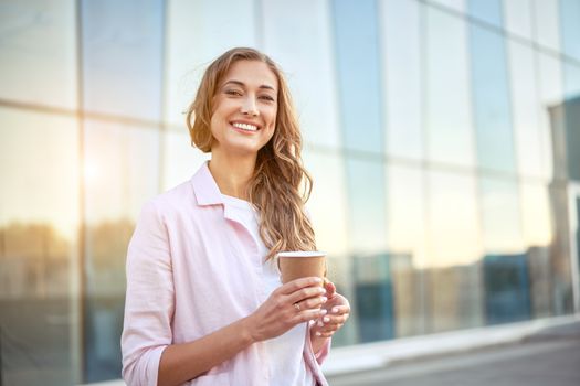 Businesswoman standing summer day near corporate building Business person Outdoors Successful european caucasian woman freelancer dressed denim jeans white shirt pink jacket