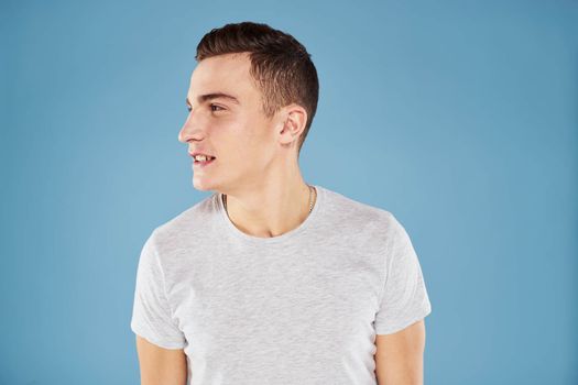 Emotional man in white t-shirt cropped view on blue background lifestyle. High quality photo