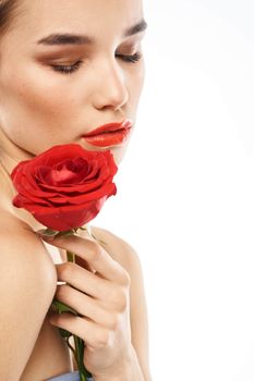 Beautiful woman with red rose near face makeup naked shoulders portrait. High quality photo