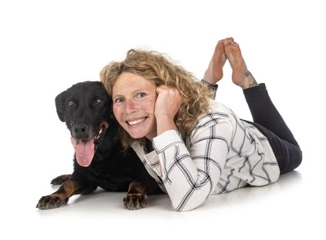 old beauceron and woman in front of white background