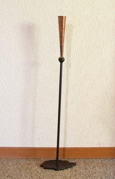 Old metal candle stand, white wall background