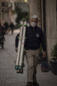 terni,italy october 26 2020:man with scale working wears medical mask cause covid 19