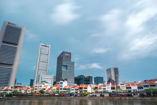 Singapore skyline with moving cloud. Waterside restaurants at Boat Quay, a historical quay by Singapore River. The place is good for relaxed evening walk, jog, drink and dinner