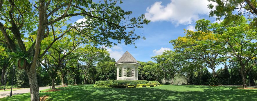 The Bandstand in Botanic Gardens, Singapore, surrounded by terraced flower beds and palms. The place is a favourite wedding photo spot and an iconic landmark of the Gardens.