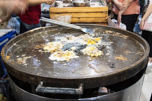Chef cooking food fry Pan-fried crispy mussel at Street food at Yoawaraj Road Bangkok Thailand 
