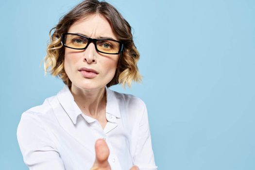 Business woman in a light shirt on a blue background gestures with her hands emotions model work. High quality photo