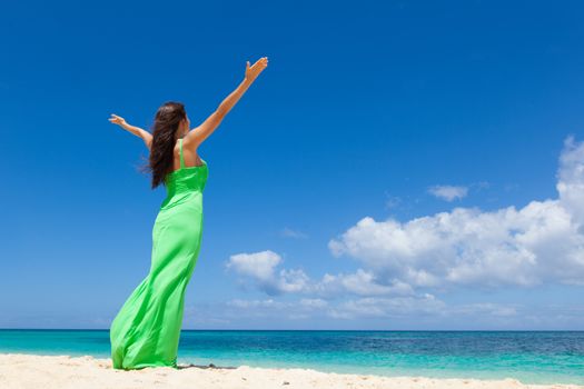 Happy woman enjoy vacation on beach walking with raised hands