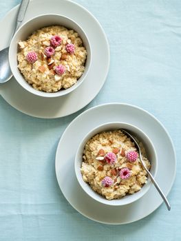 Quinoa porrige on tabletop. Two bowl wit quinoa milk porridge with berries and almond. Top view or flat lay. Vertical.