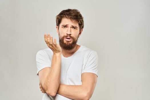 man in white t-shirt gesturing with his hands studio dissatisfaction lifestyle light background. High quality photo