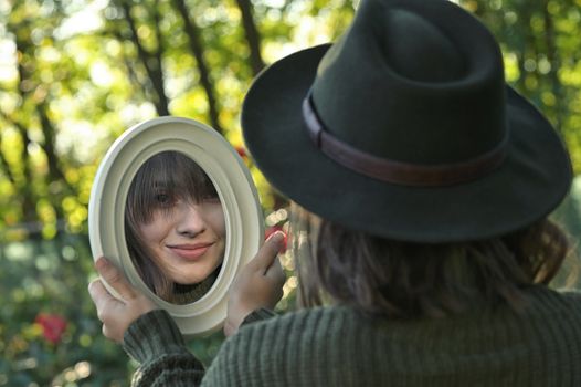 Portrait Young Woman Looking in the Mirror In Forest