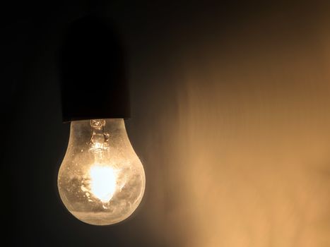 Vintage light bulb glowing in the dark. Ideal for concepts.