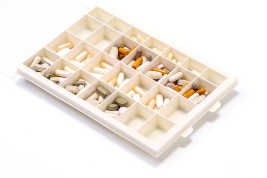 plastic medicine organizer with pills and capsules, medicines for health, pharmaceutical health care and sciences concept, shallow depth of field