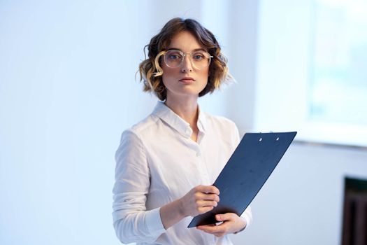 Business woman in the office with documents in the hands of the window in the background finance work. High quality photo