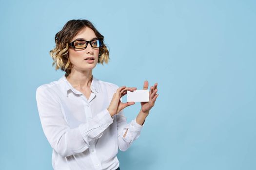 Woman wearing business card glasses in hands on blue background Copy Space cropped view. High quality photo