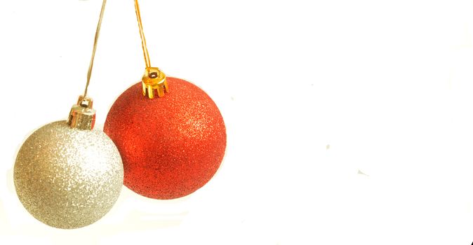 Red and golden christmas ball hanging on ribbon on white background, copyspace.