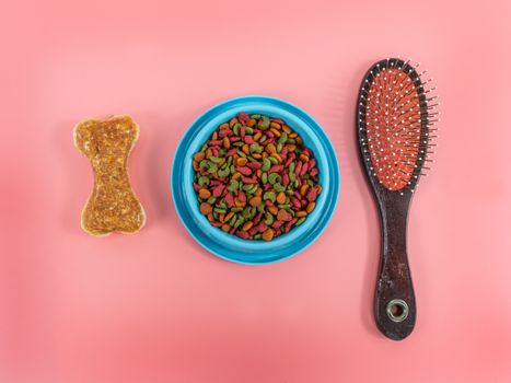 Dry food in bowls with bone and comb for pets on color background.  Flat lay concept