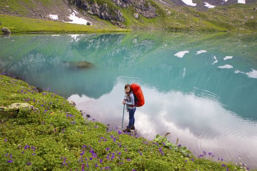 Hiker and backpacker in the mountain valley and field, trekking and hiking scene in Svaneti, Georgia, young and adult woman.