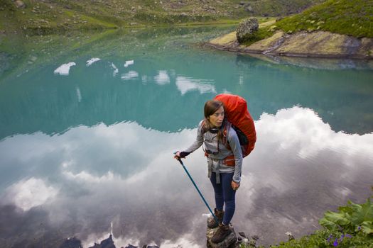 Hiker and backpacker in the mountain valley and field, trekking and hiking scene in Svaneti, Georgia, young and adult woman.