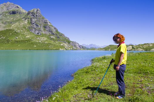 Hiker and backpacker in the mountain valley and field, trekking and hiking scene in Svaneti, Georgia, young and adult woman.