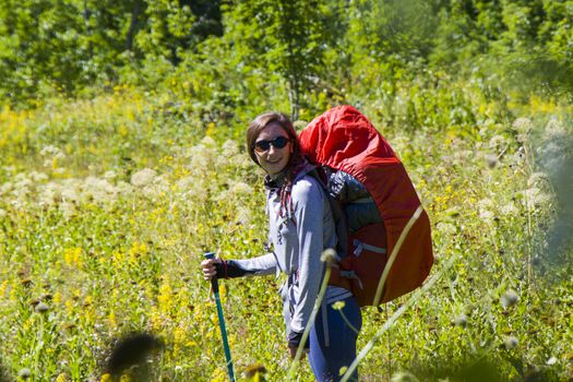 Hiker and backpacker in the mountain valley and field, trekking and hiking scene in Svaneti, Georgia, young and adult woman.