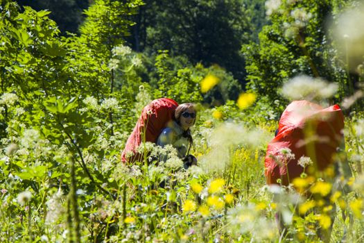 Hiker and backpacker in the mountain valley and field, trekking and hiking scene in Svaneti, Georgia, young and adult woman.