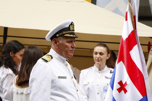 TBILISI, GEORGIA - MAY 26, 2018: Georgian marine portrait at the ceremony of independent day, young woman marines background and Georgian flag.