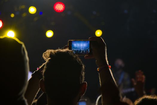 Live music concert, night life and crowd people, standing and listening music young adult people. Dark and lights.