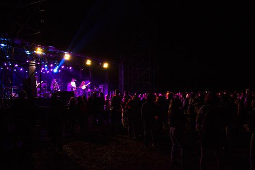 Live music concert, night life and crowd people, standing and listening music young adult people. Dark and lights.