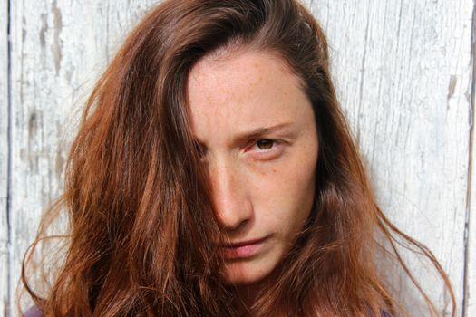 Woman portrait on the wooden background. Young beautiful ginger woman. Pretty face.