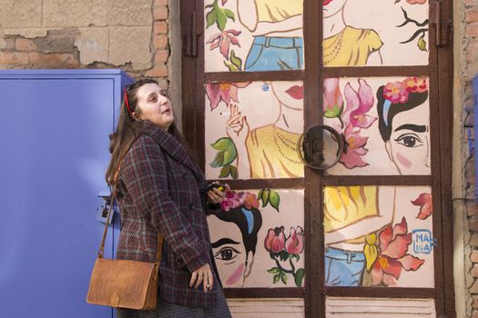 Young woman portrait, beautiful girl, pretty and cute girl on the building and architecture door background. Tourist scene.