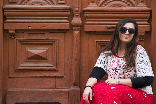 Young woman portrait, beautiful girl, pretty and cute girl on the building and architecture door background. Tourist scene.