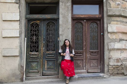 Young woman portrait, beautiful girl, pretty and cute girl on the building and architecture door background. Tourist scene.