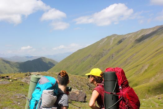 Hikers on the mountain landscape background, young girl backpacker in mountain. Georgian nature. Beautiful woman travel scene.