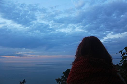 Young girl traveler looking in horizon, Black sea at sunset, Georgia