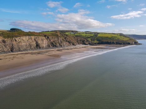 Tall Crumbling Cliffs Overlooking The Sandy Telpyn Beach And Light Blue Sea At Amroth, Pembrokeshire, Wales, UK.