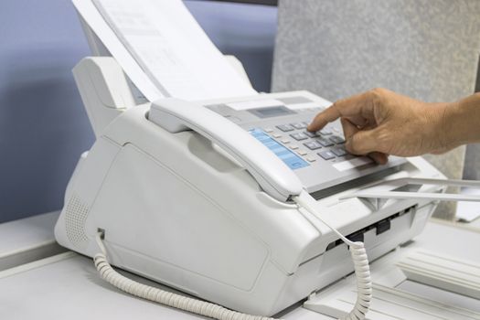 hand man are using a fax machine in the office, equipment for data transmission.