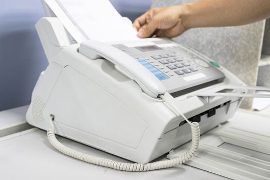 hand man are using a fax machine in the office, equipment for data transmission.