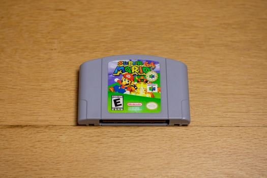A Cartridge of Super Mario 64 for the Nintendo 64 on a wood floor.