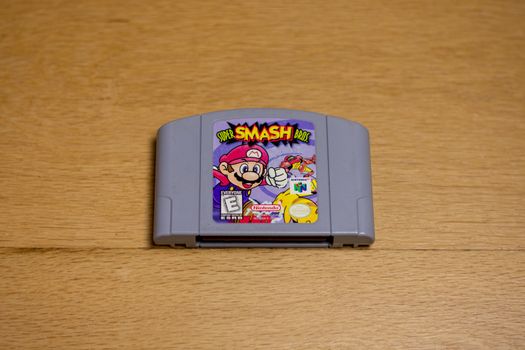 A Super Smash Bros Cartridge for the Nintend0 64 on a wood floor.