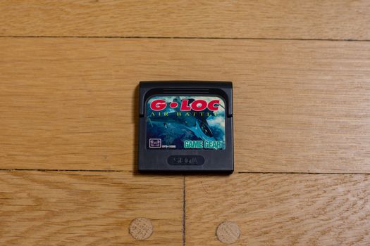 A Cartridge of G-Loc Air Battle for the Sega Gamegear on a wood floor