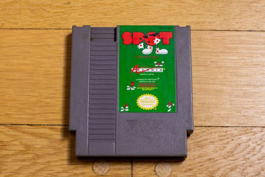 A Spot Cartridge for the Nintendo Entertainment System on a wood floor.