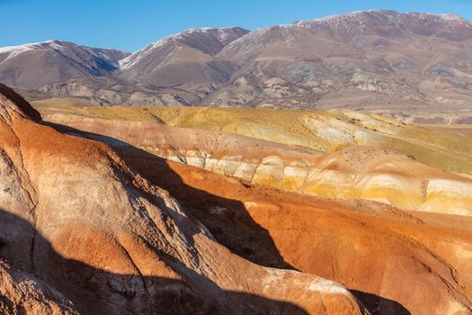 High angle shot of massive red mountains in Kyzyl-Chin valley, also called Mars valley. Blue sky as a background. Altai, Siberia, Russia.